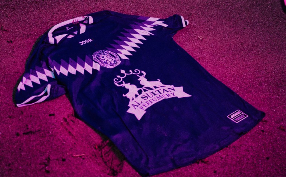The home shirt laid out on the sand