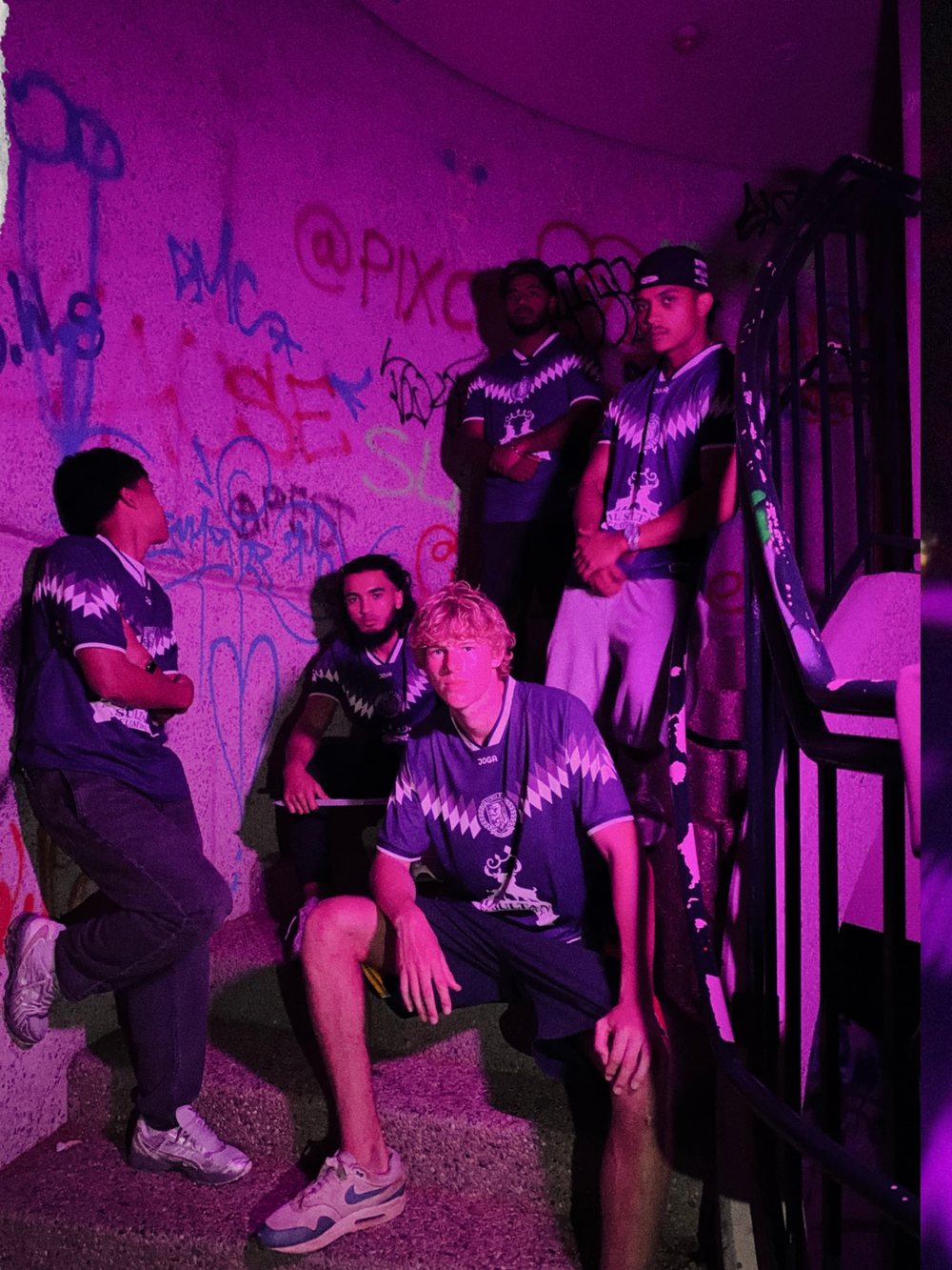 The squad in the home kit on a graffitied stairwell at night